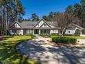 Stately gray home featuring manicured lawn, circular driveway, and lush landscaping against a backdrop of mature trees at 464 Rosemont Dr, Durham, NC 27713