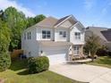 Two-story home with two-car garage, complemented by lush lawn and well-maintained landscaping at 5240 Holly Ridge Farm Rd, Raleigh, NC 27616