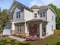 Charming home with covered porch, stone accents, and beautiful landscaping with colorful flowers at 5240 Holly Ridge Farm Rd, Raleigh, NC 27616