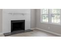 Close up of a fireplace, mantle and windows bringing in plenty of natural light at 567 Howard Tant Rd, Zebulon, NC 27597