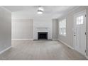 Bright living room with fireplace, modern flooring, fresh paint, and natural light at 567 Howard Tant Rd, Zebulon, NC 27597