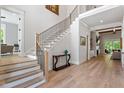 Spacious foyer with staircase, hardwood floors, modern railing, and neutral paint at 5803 Vintage Oak Ln, Raleigh, NC 27613