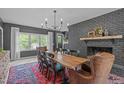 Bright dining room featuring a brick fireplace, large windows, and a spacious wooden table at 615 Beaver Creek Rd, Apex, NC 27502