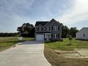 Beautiful two-story home with gray siding, a two-car garage, and a long concrete driveway at 63 Coharie Dr, Lillington, NC 27546