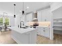 Modern kitchen with white cabinets, stainless steel appliances, a center island, and pendant lighting at 648 Shawnee Dr, Louisburg, NC 27549