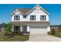 A charming two-story home with white siding, a covered entry, and a two-car garage at 76 Arlie Ln, Lillington, NC 27546