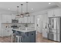 The kitchen features a large island, stainless steel appliances and white cabinets at 76 Arlie Ln, Lillington, NC 27546