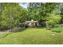 Expansive green lawn and mature trees surround this charming one-story home creating a serene setting at 804 Old Mill Rd, Chapel Hill, NC 27514