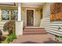 Inviting front porch with stained wood steps, stylish lighting, and an artisan wall hanging at 804 Old Mill Rd, Chapel Hill, NC 27514