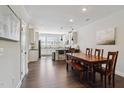 Bright dining area with hardwood floors, a wooden table, and a view into a modern, updated kitchen at 805 Winter Meadow Dr, Wake Forest, NC 27587