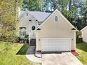 A traditional-style home with a manicured lawn, two-car garage, and a welcoming front entrance at 8629 Swarthmore Dr, Raleigh, NC 27615