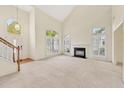 Bright living room with soaring ceilings, large windows, and a cozy fireplace for comfortable living at 8629 Swarthmore Dr, Raleigh, NC 27615