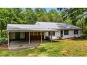 Home's charming exterior features a carport and brick foundation, nestled in a serene green yard at 901D Gibson Rd, Mebane, NC 27302