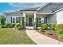 Inviting front porch with decorative plants, and a 'Welcome' sign offering a warm entrance at 93 Fallingbrook Dr, Kenly, NC 27542
