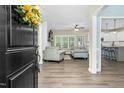 Open-concept living room with hardwood floors, a white fireplace, and comfortable seating area at 93 Fallingbrook Dr, Kenly, NC 27542