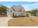 Lovely two-story home with attached garage and basketball hoop, set on a well-maintained lawn and manicured landscape at 101 Jewell Farm Lane, Holly Springs, NC 27540