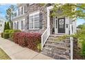 Inviting front entrance with stone steps, decorative wreath, and well-maintained landscaping, providing a welcoming curb appeal at 101 Jewell Farm Lane, Holly Springs, NC 27540