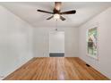 Spacious bedroom featuring hardwood floors, white walls, a ceiling fan, and natural light at 104 Argyle Ct, Garner, NC 27529