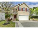 Charming two-story home with a well-manicured lawn, inviting entrance, and red shutters at 104 Caley Rd, Apex, NC 27502