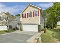 Charming two-story home with a well-manicured lawn, inviting entrance, and red shutters at 104 Caley Rd, Apex, NC 27502