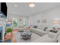 Bright living room features hardwood floors, plush furniture, and large windows overlooking a lush yard at 107 Candy Apple Ct, Cary, NC 27513