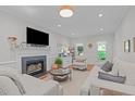 Inviting living room showcasing a cozy fireplace, plush seating, and natural light from surrounding windows at 107 Candy Apple Ct, Cary, NC 27513
