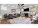 Bright and airy living room with a fireplace, modern ceiling fan, and stylish decor at 1209 Shasta Daisy Dr, Wake Forest, NC 27587