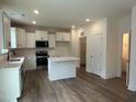 Bright kitchen featuring white cabinetry, stainless steel appliances, and an island with a quartz countertop at 1252 Randwick Vly Ct, Zebulon, NC 27597