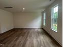 Spacious living room with hardwood floors, recessed lighting, and large windows offering plenty of natural light at 1252 Randwick Vly Ct, Zebulon, NC 27597