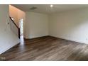 Open-concept living area with hardwood floors and a staircase leading to the upper level of the home at 1252 Randwick Vly Ct, Zebulon, NC 27597