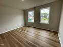 Bright bedroom with new wood flooring, two large windows, and neutral walls at 127 Oakfield Trace Dr, Four Oaks, NC 27524