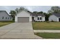 Charming single-story home featuring a gray garage door, light gray siding, and a well-manicured lawn at 139 Oakfield Trace Dr, Four Oaks, NC 27524