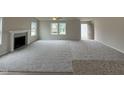 Bright, open living room with a fireplace, plush carpet, and lots of natural light from several windows at 139 Oakfield Trace Dr, Four Oaks, NC 27524