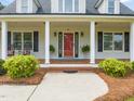 Inviting front porch with classic columns, a bright red door, and manicured landscaping at 140 Crystal Pl, Benson, NC 27504