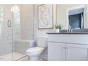 Elegant bathroom features a glass enclosed shower with marble tile, white vanity and modern fixtures at 1484 Hasse Ave, Apex, NC 27502