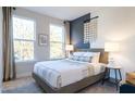 Comfortable bedroom featuring large windows, gray carpet, stylish decor, and natural light at 1486 Hasse Ave, Apex, NC 27502