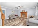 Bright living room featuring wood-look floors, a brick fireplace, and neutral paint, creating a cozy atmosphere at 1576 Cheves Rd, Zebulon, NC 27597