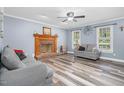 Comfortable living room showcasing a brick fireplace, wood-look floors, and stylish decor for a welcoming space at 1576 Cheves Rd, Zebulon, NC 27597