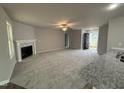 Spacious living room with a fireplace, neutral carpet, and an open entrance at 163 Oakfield Trace Dr, Four Oaks, NC 27524