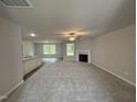 Bright living room with a fireplace, ceiling fan, and lots of natural light at 163 Oakfield Trace Dr, Four Oaks, NC 27524