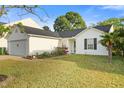 White single-story home with a lush green lawn and colorful flower beds in the front yard at 1725 E Honey Springs Ave, Fuquay Varina, NC 27526