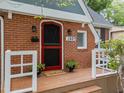 Close-up of the red brick home entrance, showcasing the red door and welcoming porch at 1809 Glendale Ave, Durham, NC 27701