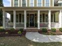 Inviting covered front porch with white columns and charming front door at 200 Larkhaven Pl, Apex, NC 27539