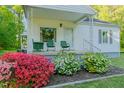 Charming front porch with chairs, complemented by vibrant azaleas and a manicured lawn at 2021 Bundy Ave, Durham, NC 27704