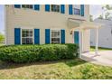 Home featuring blue shutters, green bushes, and covered front entryway at 2032 Lime St, Durham, NC 27704