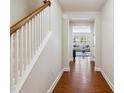 Inviting hallway with hardwood floors, white walls, and view of the living room at 205 Begen St, Morrisville, NC 27560