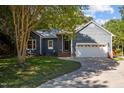 Inviting blue home with a well-kept lawn, mature landscaping, and a convenient two-car garage at 2123 Fountain Ridge Rd, Chapel Hill, NC 27517