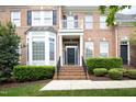Beautiful brick townhome with a covered entry, manicured bushes, and an inviting staircase at 2318 Carriage Oaks Dr, Raleigh, NC 27614