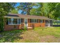 Charming brick home with a covered parking area and a well-manicured lawn at 2500 Courtland Dr, Sanford, NC 27330