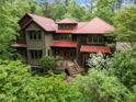 Attractive multi-level home with a red roof surrounded by lush green trees and shrubbery at 2917 Ericka Dr, Hillsborough, NC 27278